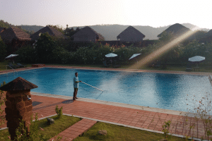 a man cleaning a big swimming pool