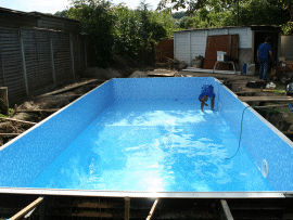 An in-ground swimming pool in the midst of installation or repair for a Pool Services, Maintenance & Installation Tips blog