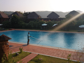 A photo with a person cleaning a pool in the background at a resort