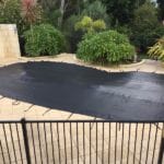 A residential security mesh cover for the pool, in black for maximum heat absorption